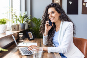 A woman is sitting at a desk using a laptop