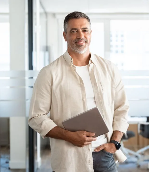 A smiling benefits specialist holding a tablet in a bright office